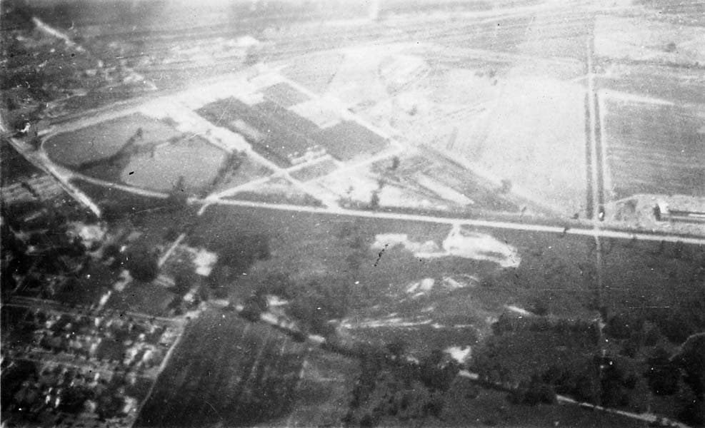 An aerial view showing intersecting roads and large plots of land, captured from a high altitude.
