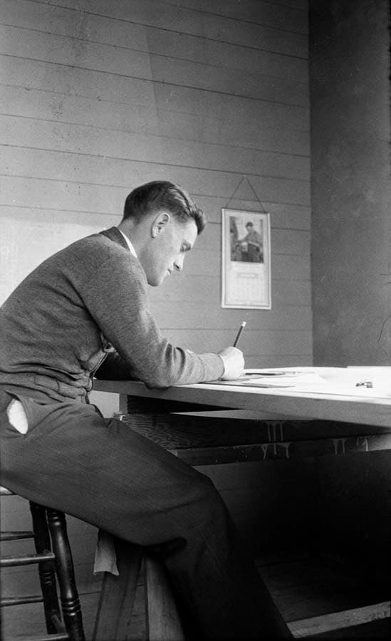 A pristine, iconic side-profile portrait of Donald A. Hall Sr. working intently at his drafting table.