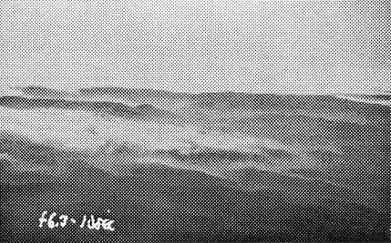 A grainy halftone print of an aerial landscape with handwritten camera settings reading f6.3 - 1/100 sec at the bottom.