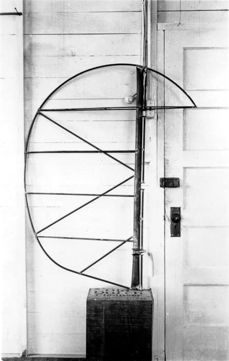 The bare tubular steel framework of the Spirit of St. Louis vertical stabilizer and rudder, resting against a wooden door.