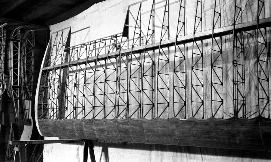 The intricate wooden rib framework of the Spirit of St. Louis wing under construction, resting on sawhorses in the factory.