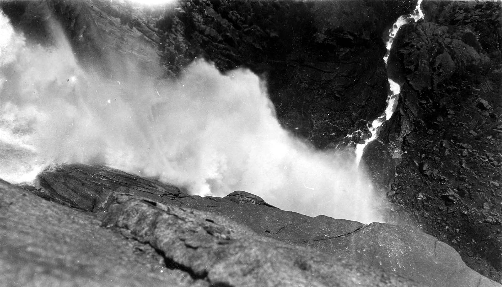 Looking straight down over the sheer granite lip of Upper Yosemite Fall into the churning mist and canyon chasm far below.