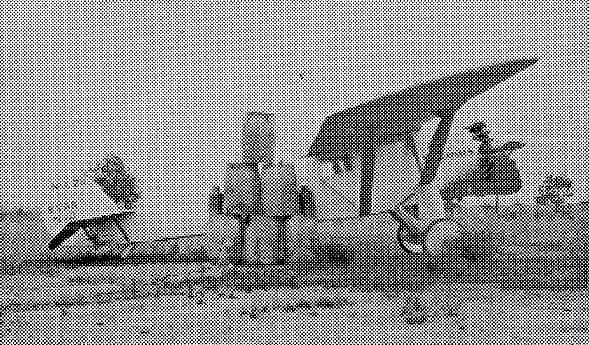 Halftone print of the Spirit of St. Louis on the ground at Camp Kearny with stacked 55-gallon fuel barrels.