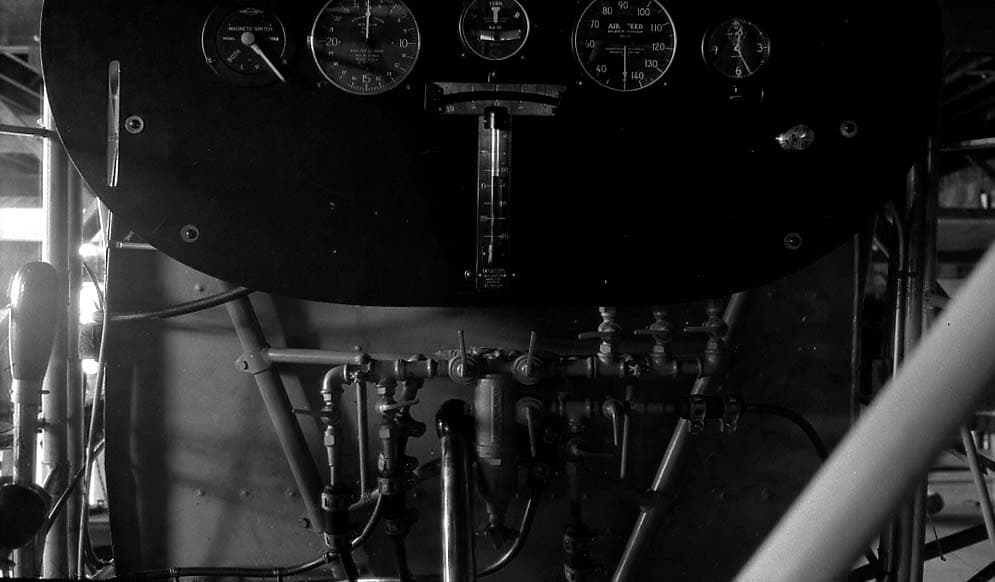 Engineering photograph of the complex fuel manifold, brass selector valves, and copper lines beneath the instrument board.