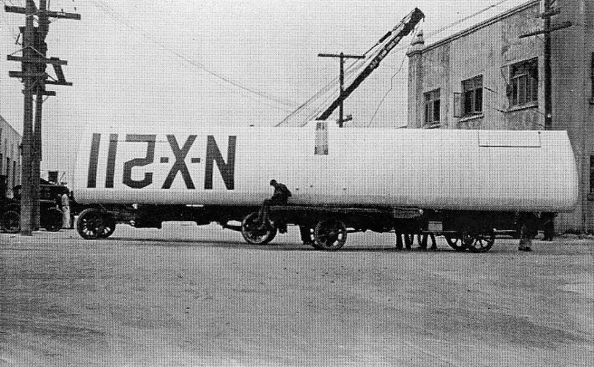 The 46-foot Spirit of St. Louis wing resting horizontally on transport dollies showing large N-X-211 registration markings.