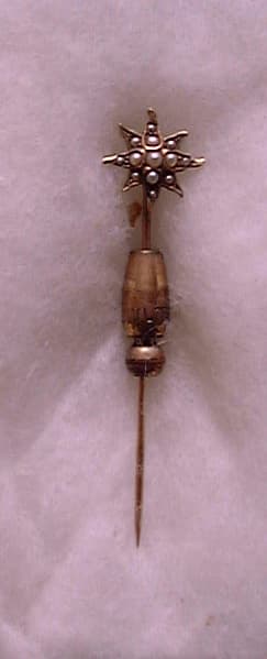 An antique eight-pointed gold stickpin set with central seed pearls and spiral locking clutch owned by Donald A. Hall.