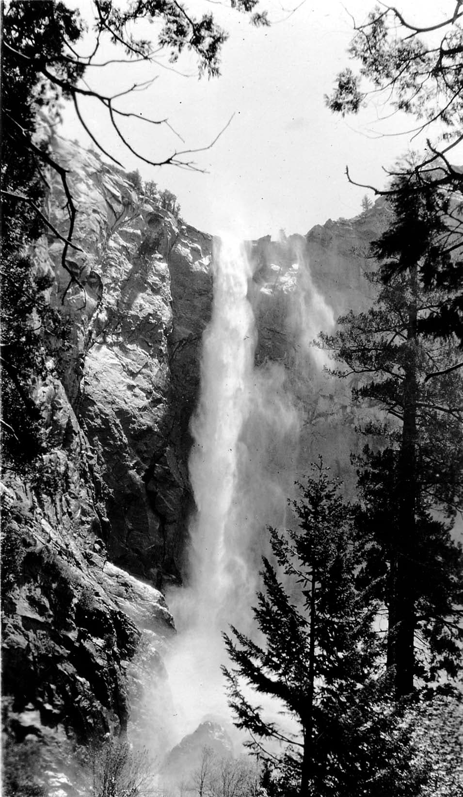 Bridalveil Fall billowing like a delicate misty veil against the towering granite cliffs of Cathedral Rocks in Yosemite Valley.