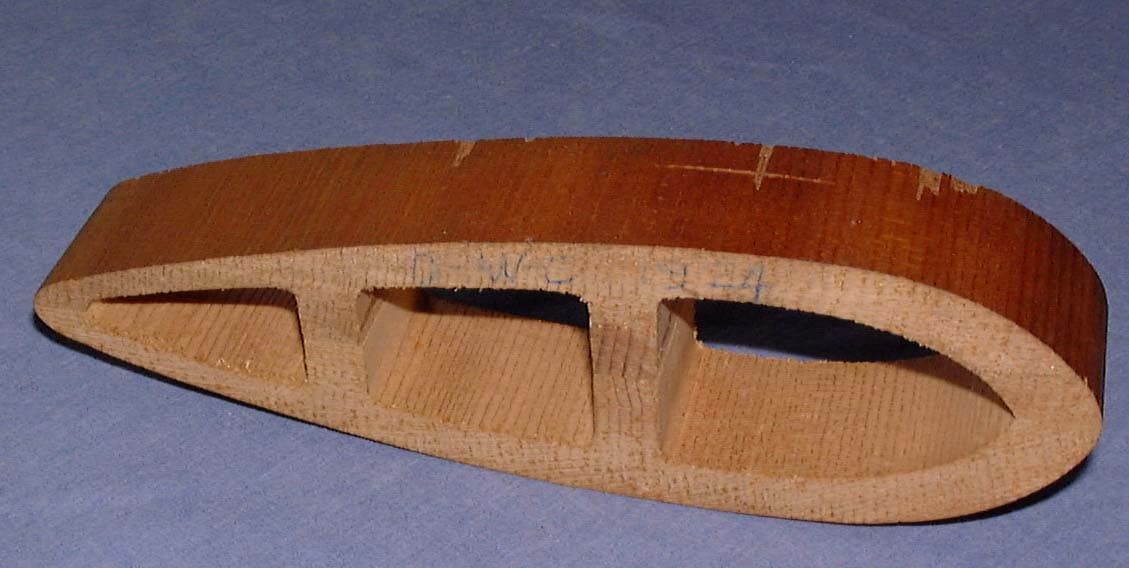 A carved wooden test rib and airfoil section with hollow cavities hand-penciled D.W.C. 1924 from the Douglas World Cruiser.