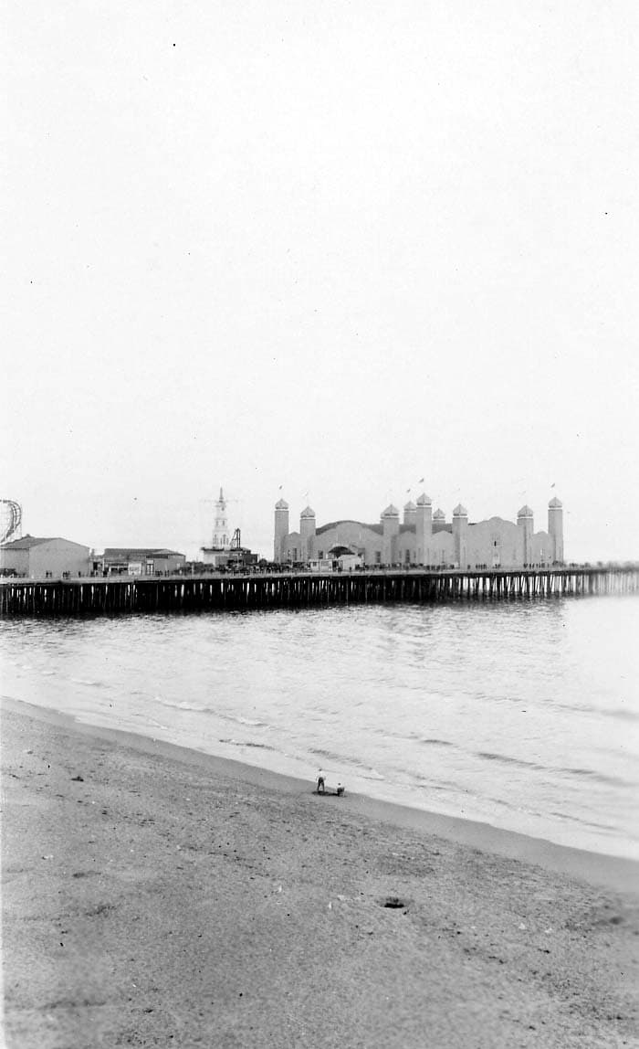 A daytime view of the historic La Monica Ballroom extending over the ocean on the Santa Monica Pier.