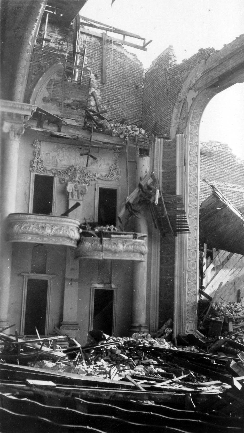 The collapsed interior of the Potter Theatre showing ornate proscenium boxes, classical molding, and massive piles of brick and roof rubble.