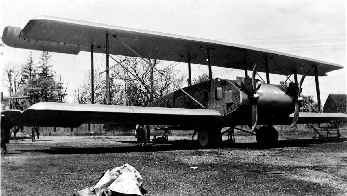 The massive Remington-Burnelli RB-2 twin-engine biplane transport constructed of corrugated duralumin metal skin parked on an airfield.