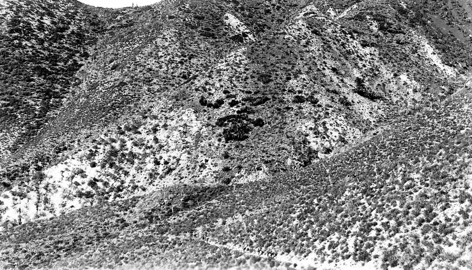 Hikers carefully making their way down a rocky slope.
