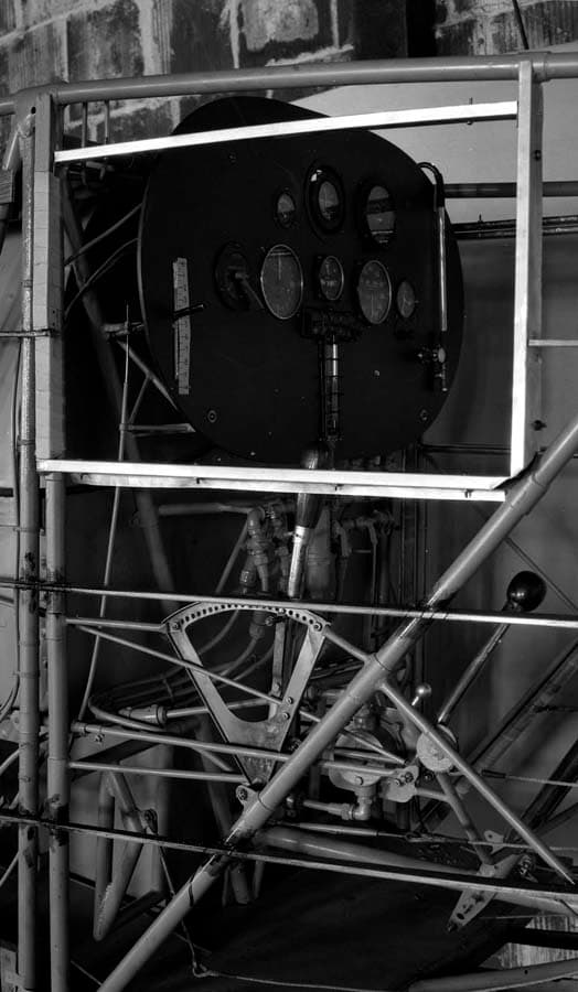 The uncovered tubular steel framework of the Spirit of St. Louis cockpit featuring the newly mounted black instrument panel and flight controls.