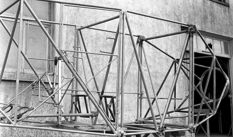 A detailed view of the forward section of the raw tubular steel fuselage framework, showing the engine mount ring and cockpit controls.