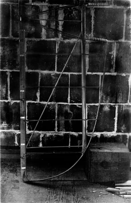 The bare tubular steel framework of the Spirit of St. Louis horizontal tail surface resting against a brick wall.