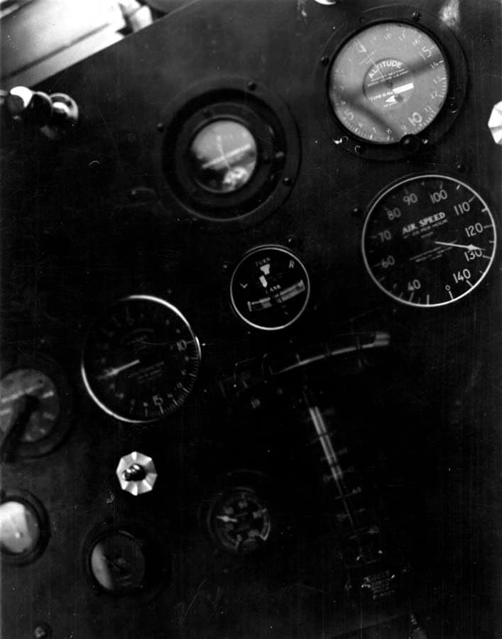 A close-up view of the Spirit of St. Louis instrument panel in mid-flight, showing the altimeter, airspeed indicator, and turn-and-bank indicator.