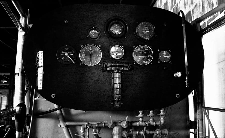 A straight-on view of the Spirit of St. Louis instrument panel, prominently featuring the intricate array of fuel distribution valves located at the bottom.