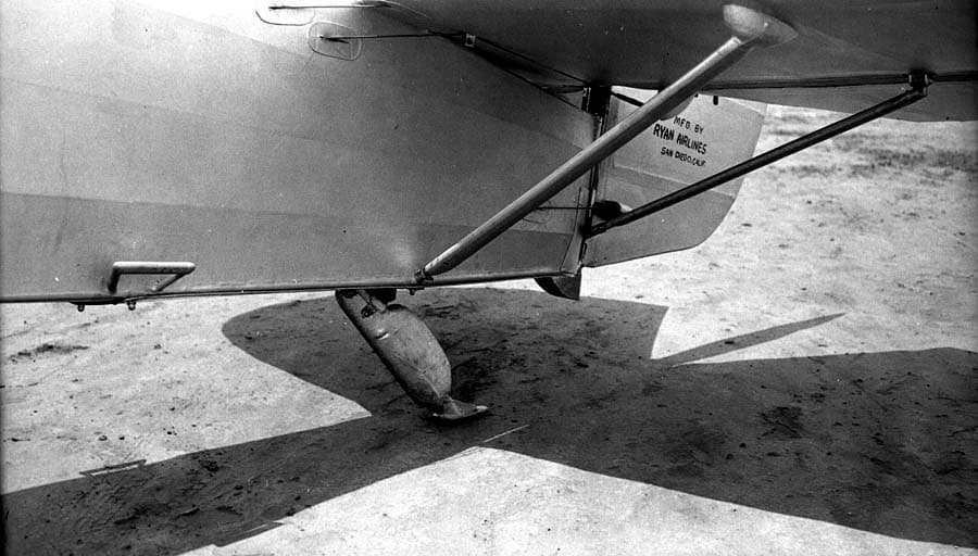 Ground-level detail photograph of the aft fuselage underside showing tail skid shoe and horizontal stabilizer struts.