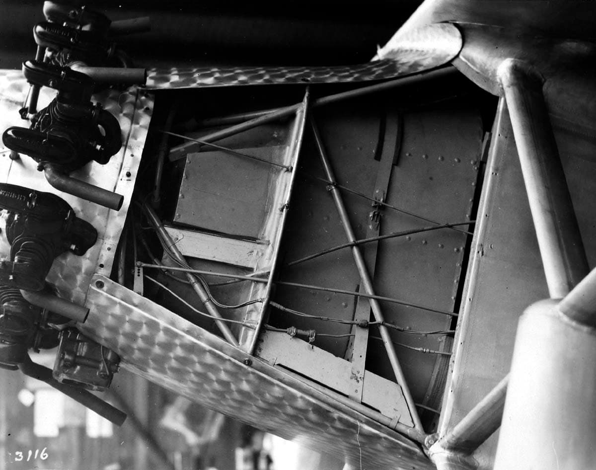 Technical photograph plate 3116 showing forward fuselage framework, oil tank, and fuel lines with side cowling removed.