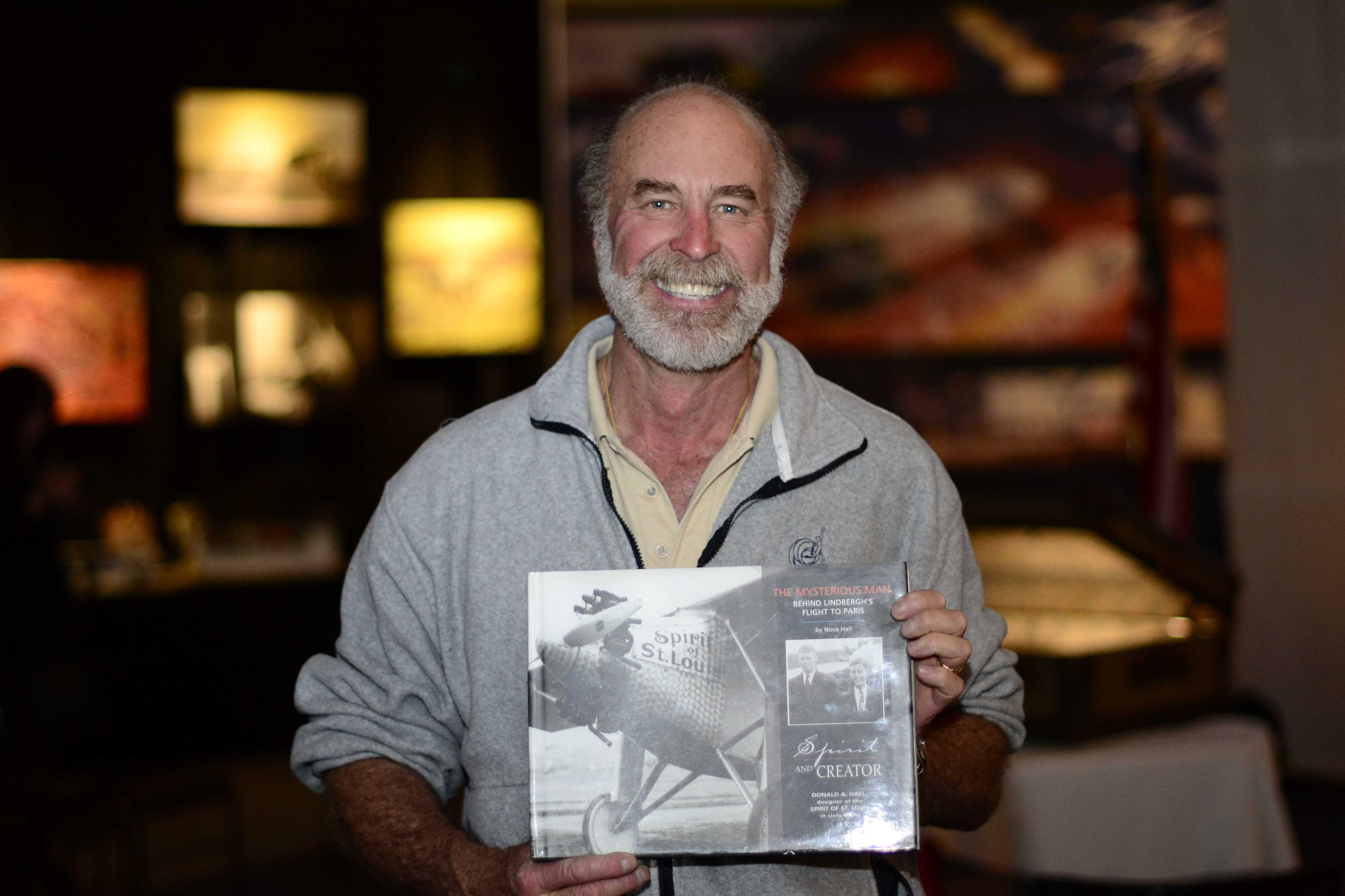 First edition hard cover book of Spirit and Creator held by pilot Kermit Weeks at the Challenger Space Center, with the Lindbergh Foundation Board of Directors in Peoria, Arizona