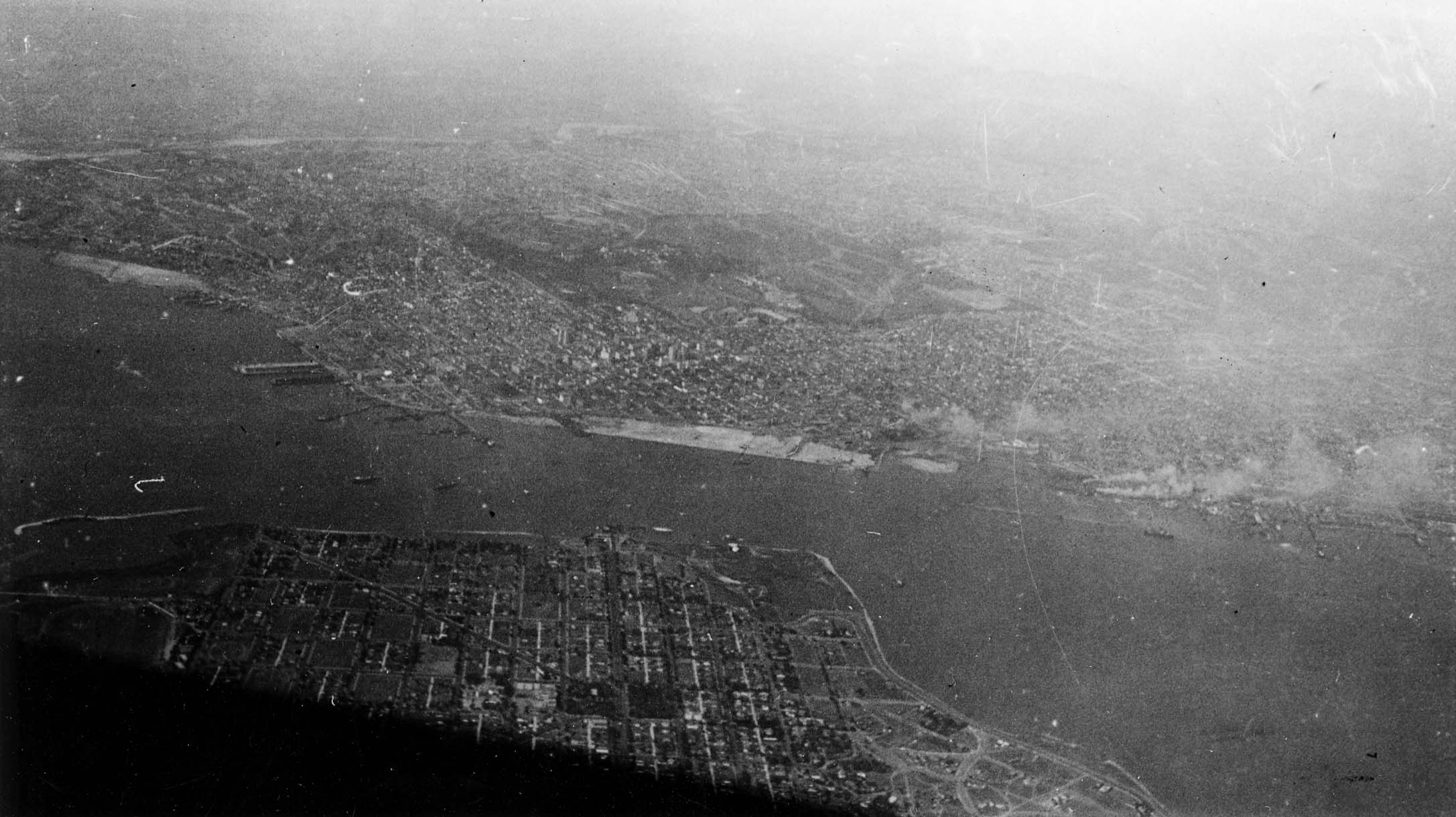 A high-altitude aerial view of the San Diego Bay, showcasing the sprawling cityscape and coastal geography.