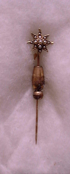 An antique eight-pointed gold stickpin set with central seed pearls and spiral locking clutch owned by Donald A. Hall.