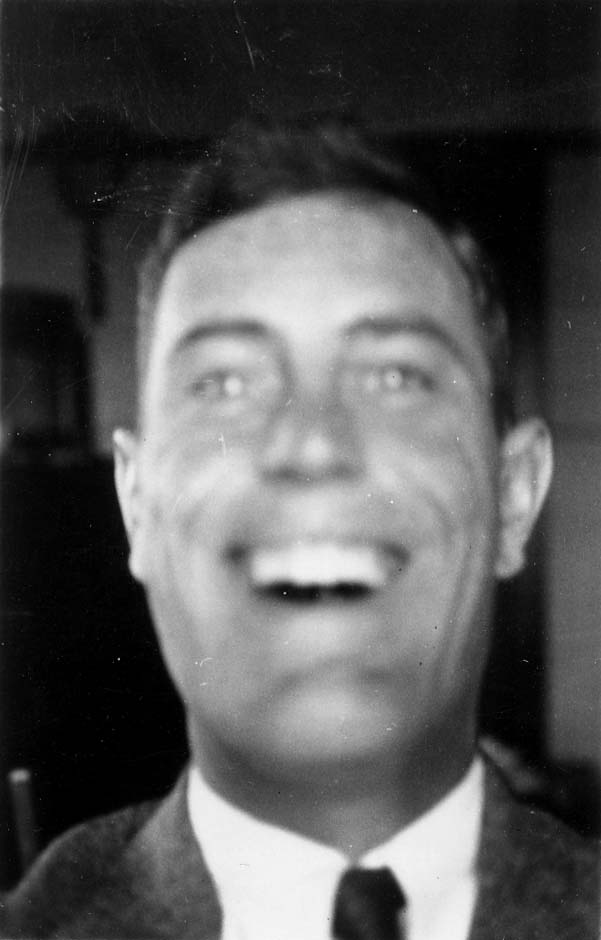 A candid close-up self-portrait of Donald A. Hall Sr. laughing broadly while dressed in a three-piece suit and necktie.