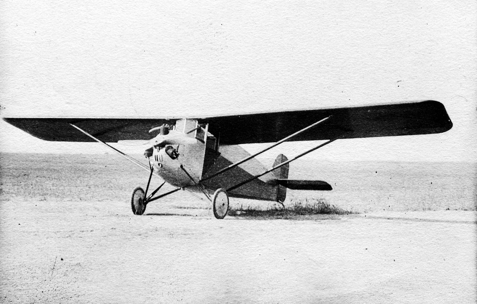 A frontal view of the experimental Driggs-Johnson DJ-1 Bumblebee ultra-light monoplane resting on an open dirt landing field.