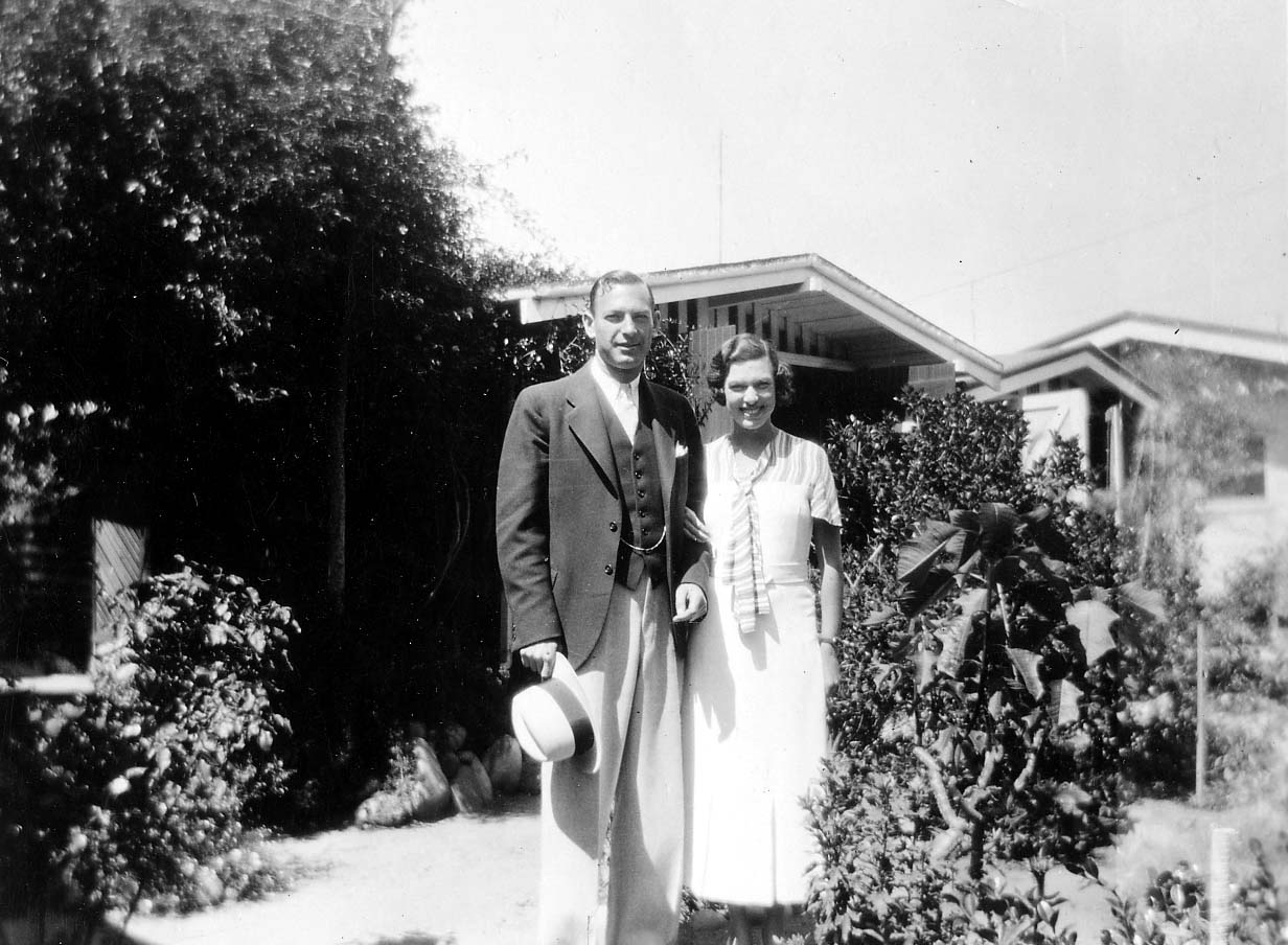 Elisabeth Betty Walker smiling in a summer dress alongside her brother Omar Walker in a three-piece suit holding a hat in a sunny garden.