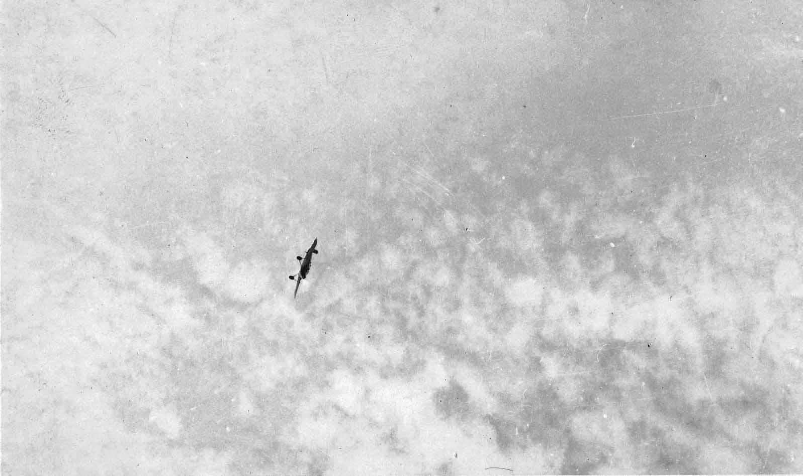 A high-altitude telephoto photograph of the Hall X-1 prototype flying completely inverted against a sky of light cirrus clouds.