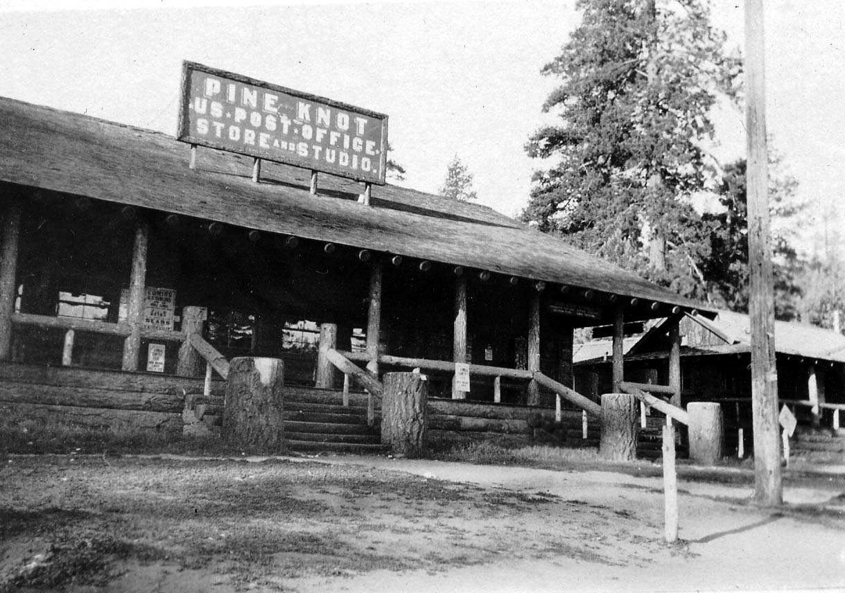 The historic log-built Pine Knot U.S. Post Office, Store, and Studio in Big Bear Lake with rustic tree-trunk pillars and gabled roof.