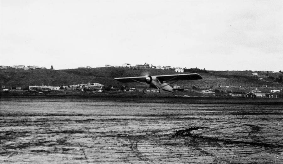 An action photograph of the Spirit of St. Louis lifting off the dirt runway at Dutch Flats during its first test flight.