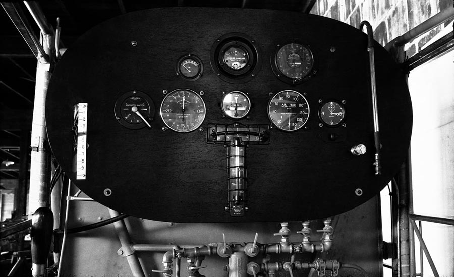 A straight-on view of the Spirit of St. Louis instrument panel, prominently featuring the intricate array of fuel distribution valves located at the bottom.