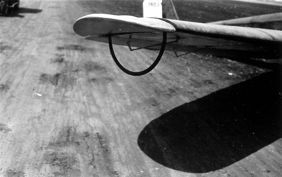 A close-up detail shot of the wingtip of the Spirit of St. Louis, showing a specialized, curved metal handling bar attached beneath the fabric surface.