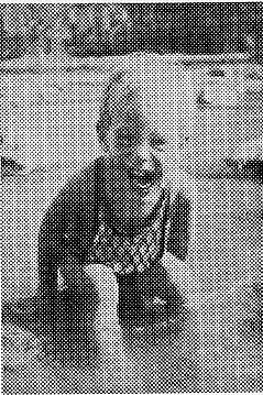 A pixelated halftone print of a young, smiling toddler, Don Hall Jr., wearing a light sweater.