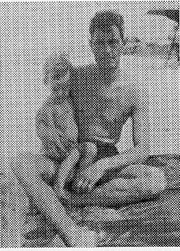Halftone print of Donald A. Hall Sr. shirtless outdoors holding his young son Donald Hall Jr. in his lap.