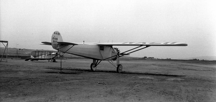 Rear photograph of the Spirit of St. Louis aircraft at Dutch Flats, San Diego, California with another airplane in background. Photo in April 1927 by Chief Engineer Donald A. Hall with elevated tail for the Center of Gravity test.