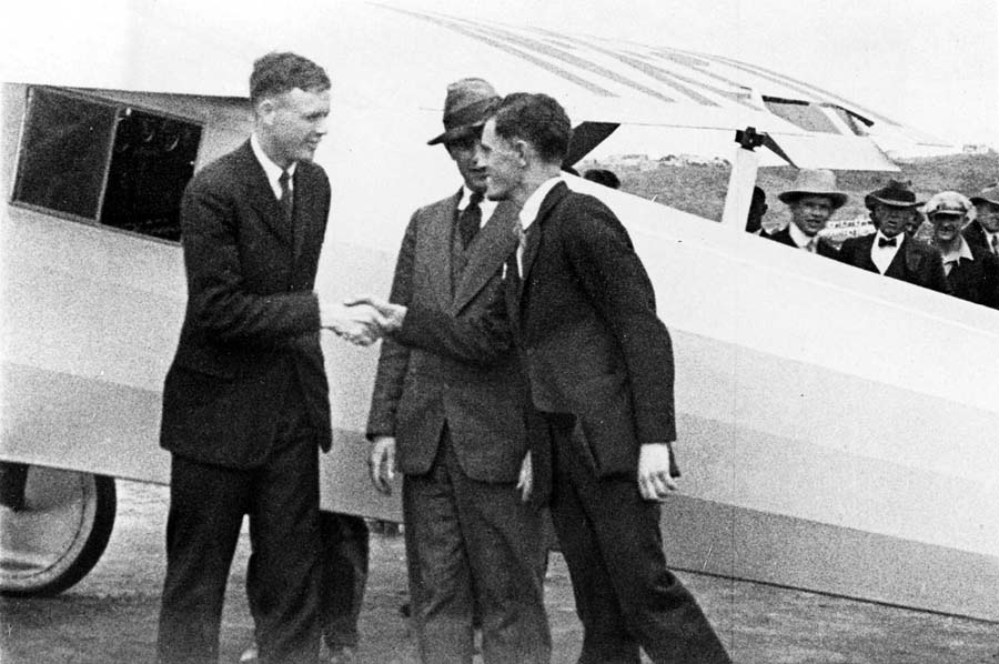 Vintage photo in 1927 with pilot Charles Lindbergh and Chief engineer Donald Hall shaking hands in front of the Spirit of St. Louis in San Diego, California. Owner Frank Mahoney is behind them.