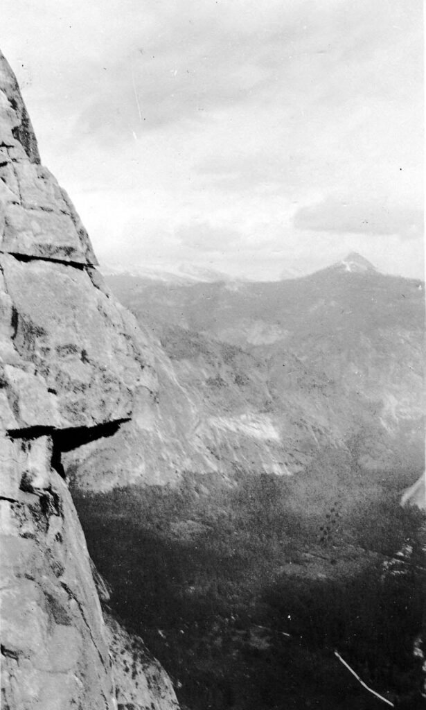Vintage black and white photograph showing the mountains in distance and the valley in foreground from El Capitan. Taken at Yosemite National Monument, California by Donald Hall.