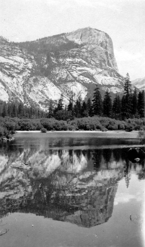 Vintage black and white photograph showing the reflection of El Capitan from the valley floor. Taken at Yosemite National Monument, California by Donald Hall.