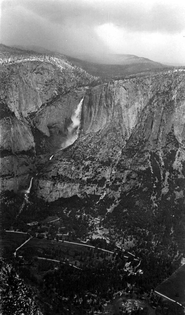 Vintage black and white photograph of a waterfall from across the valley. Taken at Yosemite National Monument, California by Donald Hall.