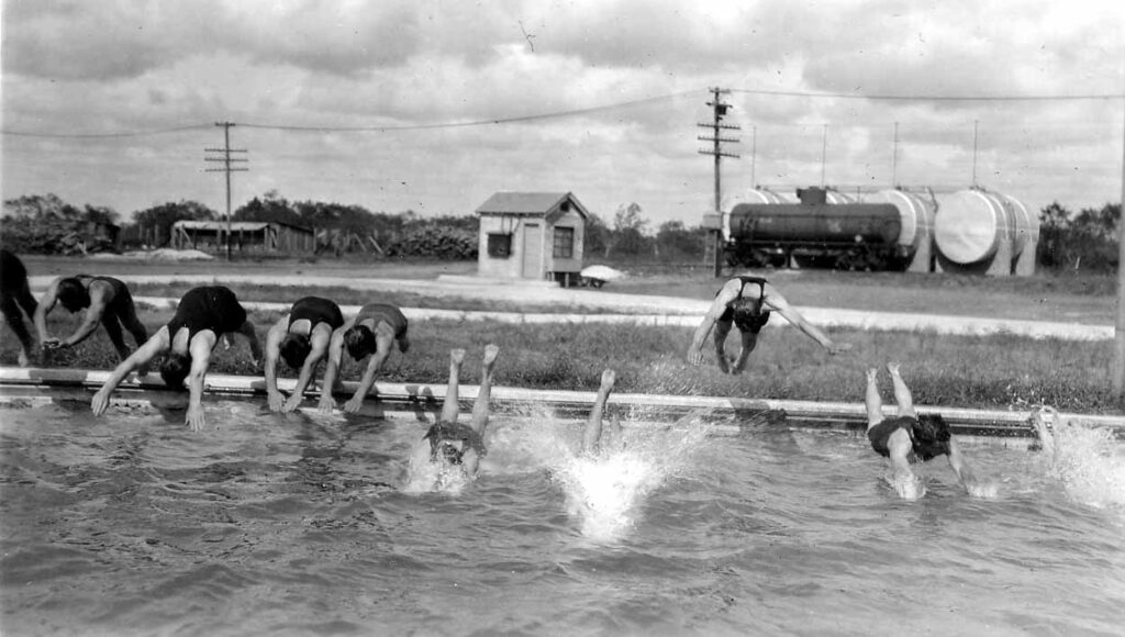 Vintage Black and White photograph of ten male divers captured in various dives including mid-air as they enter a pool. Photo taken by Donald Hall in 1925 at Brooks Field Army base in Texas.