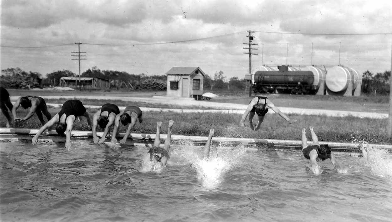 Vintage Black and White photograph of ten male divers captured in various dives including mid-air as they enter a pool. Photo taken by Donald Hall in 1925 at Brooks Field Army base in Texas.