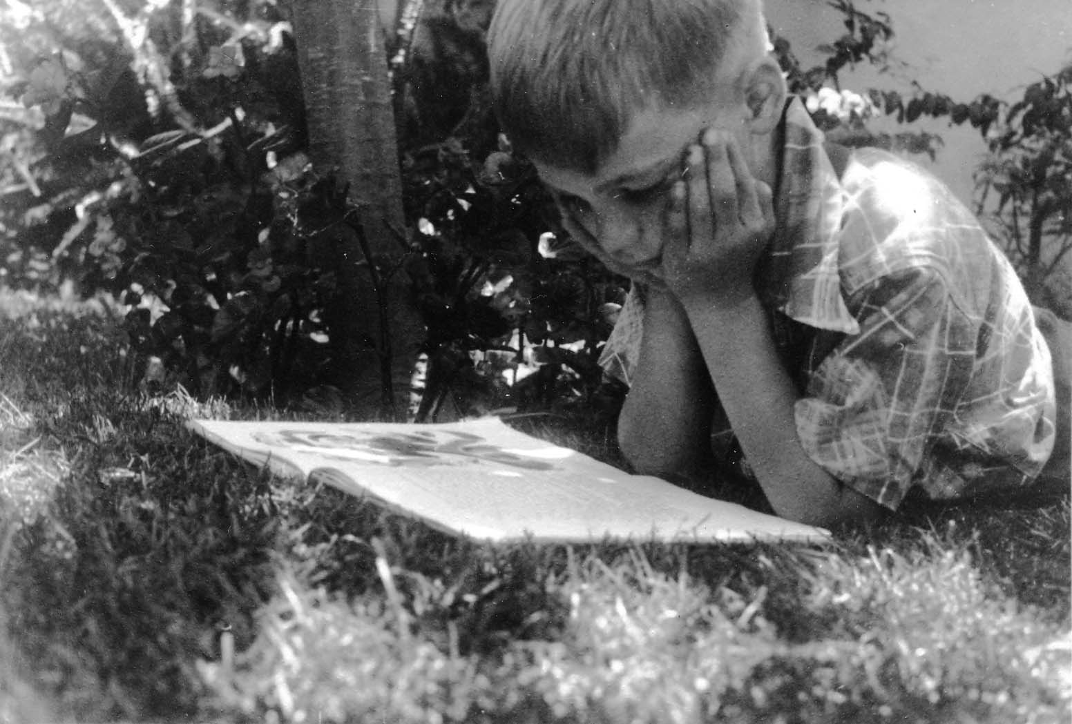 Vintage black and white photo of Don Hall, Jr reading  book at the Hall home in Point Loma, San Diego, California. Photo taken by Donald Hall, engineer of the Spirit of St. Louis