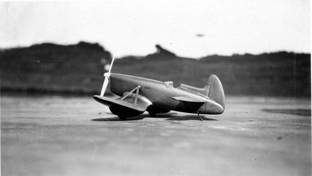 Vintage black and white side view photograph of the proposed production gull wing aircraft model with a stabilator that was designed by Donald Hall, taken on the roof of the old Ryan factory in San Diego, California in 1929.