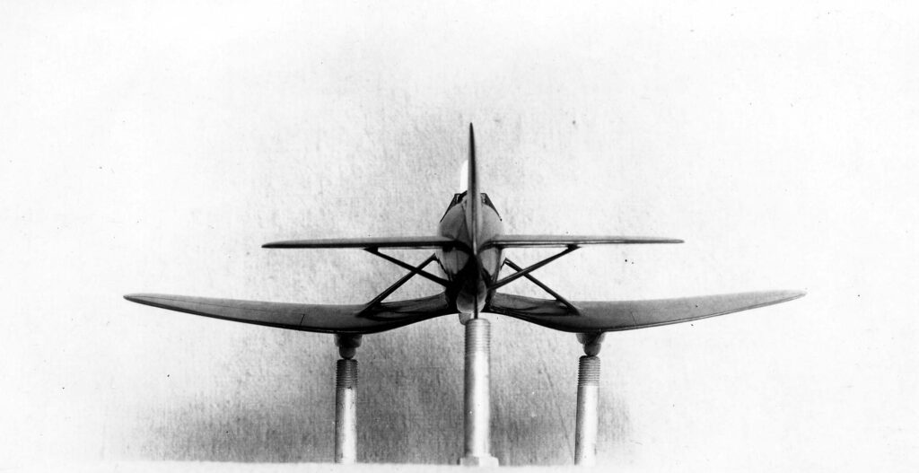 Vintage black and white rear view photograph of the proposed production gull wing aircraft model with a stabilator that was designed by Donald Hall, taken on the roof of the old Ryan factory in San Diego, California in 1929.