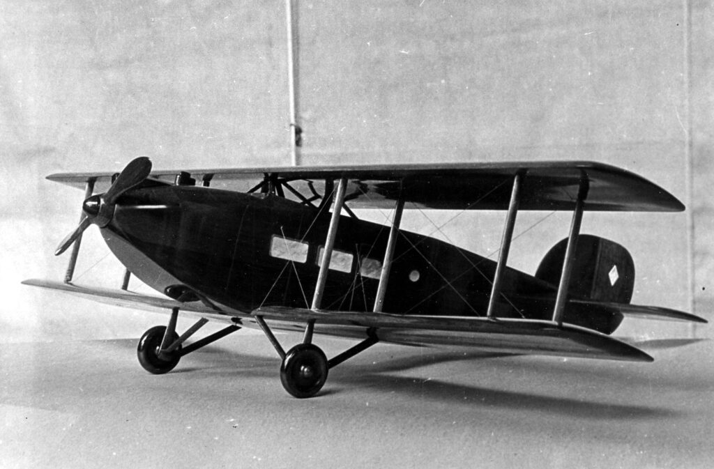 Vintage black and white photograph of a single engine bi-plane model. Probability a design of Donald Hall. This design looks similar to the Douglas Cloudster.