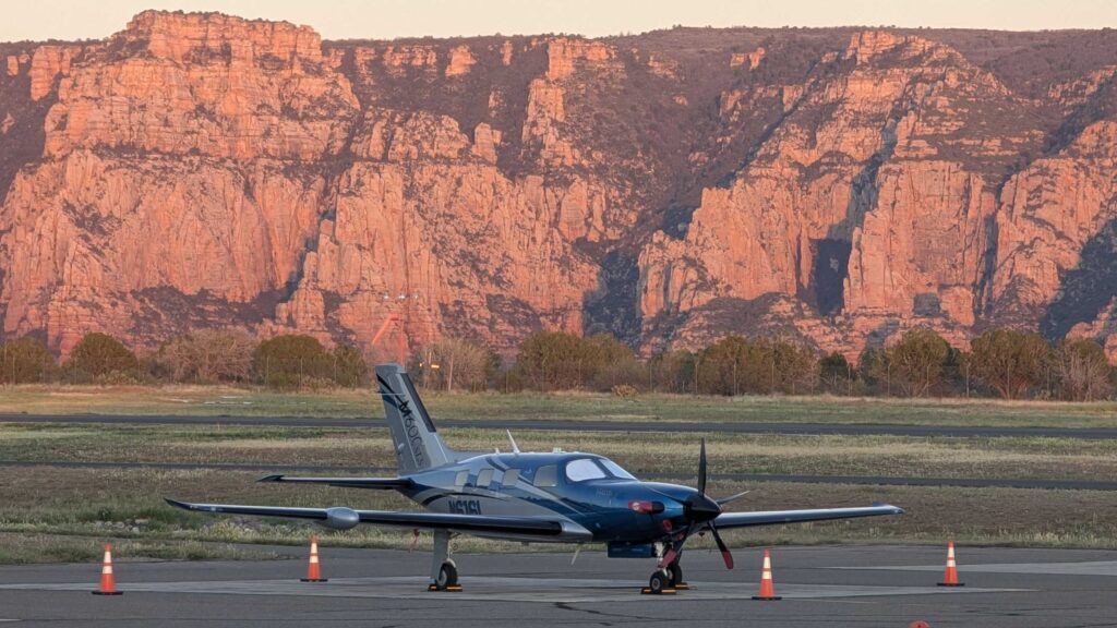 Modern Pilatus aircraft sitting on the runway in Sedona, Arizona with the red rocks glowing from the sunset in 2026